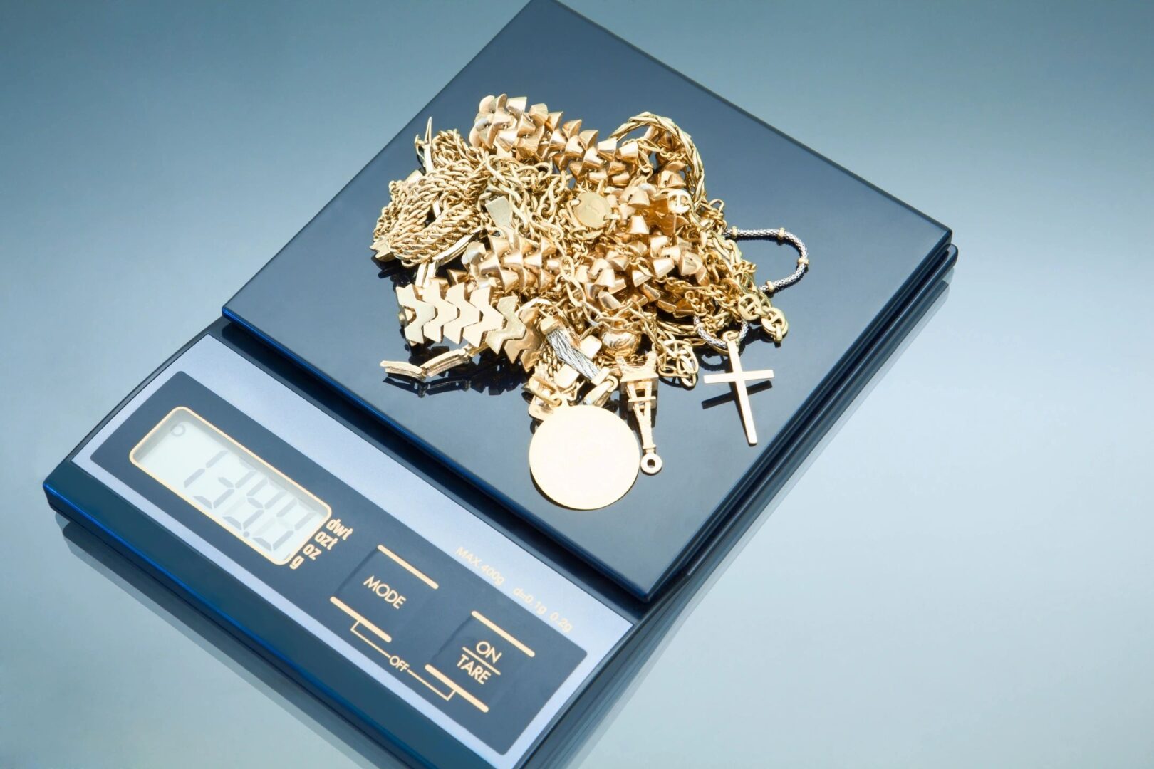 Gold jewelry on digital weighing scale.