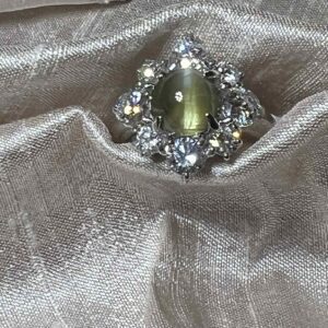 Elegant brooch with a central cat's eye gem surrounded by sparkling stones on velvet.